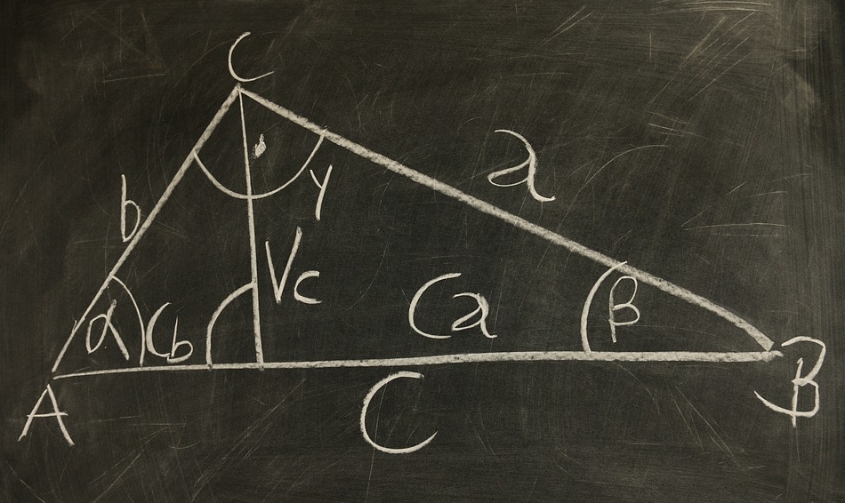Tablica szkolna, a na niej narysowany kredą trójkąt z matematycznymi obliczeniami